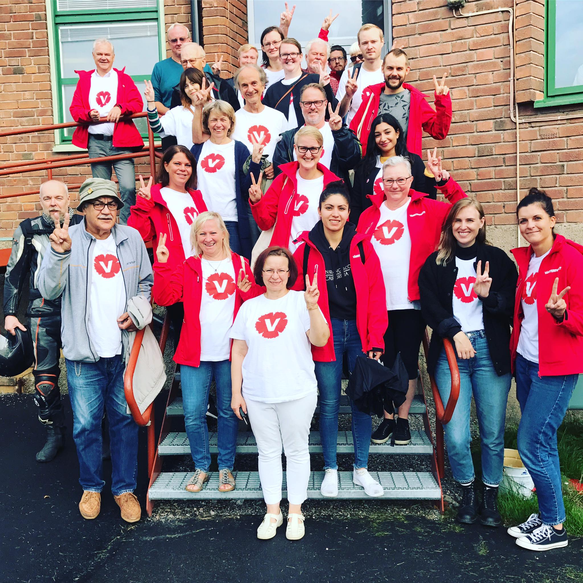 Glada Vänsterpartister som gör V-tecknet